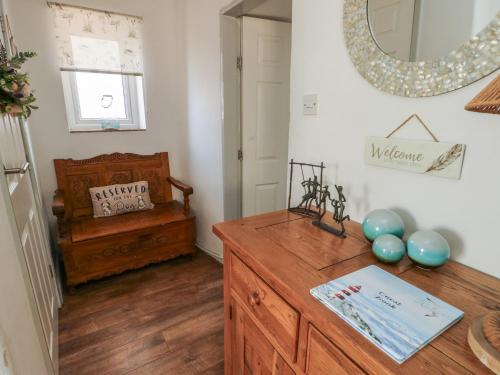 a room with a wooden dresser and a mirror at Camwy in Llanfairpwllgwyngyll
