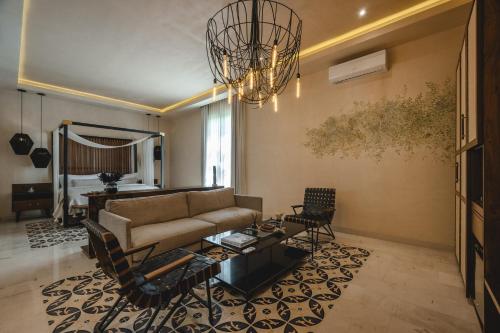 a living room with a couch and a chandelier at Adoro Hotel Boutique in Mérida
