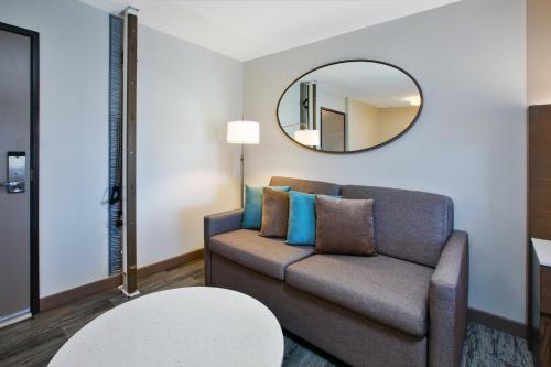 a living room with a couch and a mirror at EVEN Hotel Ann Arbor S - University Area by IHG in Ann Arbor