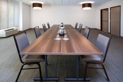 a conference room with a large wooden table and chairs at EVEN Hotel Ann Arbor S - University Area by IHG in Ann Arbor