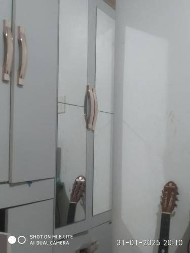 a mirror in a bathroom with a person taking a picture at Casa de tempora para cop 30 in Ananindeua