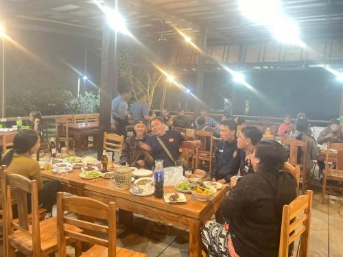 a group of people sitting at a table eating food at Vangngo View Resort, Muang Fuang in Muang Fuang