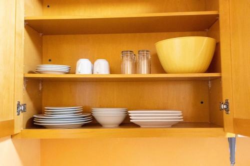 a wooden cabinet with plates and bowls on it at Tangerine Sunsets Mango in Nassau