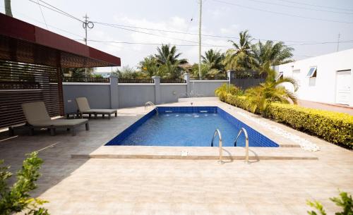 a swimming pool in the middle of a yard at De Chateau Paradise in Accra