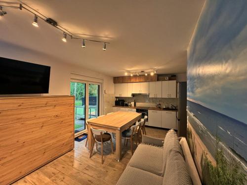 Una cocina y un comedor con una mesa y un televisor. en Ring Apartments - Międzywodzie, en Międzywodzie