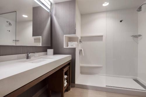 a white bathroom with a sink and a shower at Courtyard by Marriott Ardmore in Ardmore