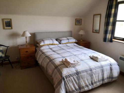 a bedroom with a bed with towels on it at Cranstakie Cottage in Durness