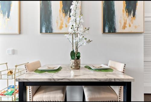 a dining room table with chairs and a vase of flowers at NEW! Royal Penthouse King Bed Amazing Views! in Atlanta