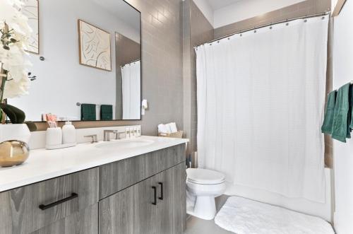 a bathroom with a sink and a toilet and a mirror at NEW! Royal Penthouse King Bed Amazing Views! in Atlanta