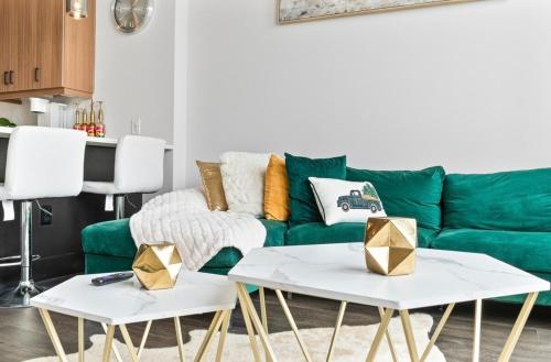 a living room with a green couch and two tables at NEW! Royal Penthouse King Bed Amazing Views! in Atlanta