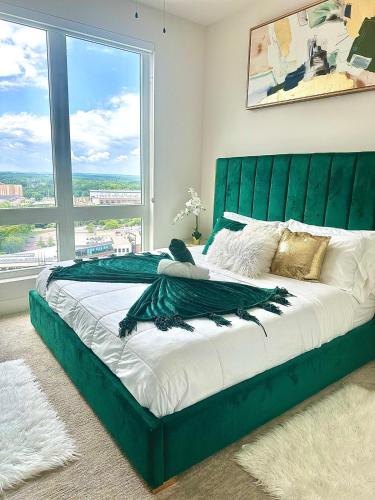 a large green bed in a bedroom with a large window at NEW! Royal Penthouse King Bed Amazing Views! in Atlanta