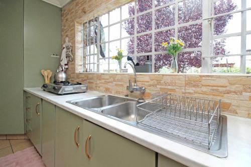 a kitchen sink with a metal dish rack on it at Daily Fresh Farmhouse in Johannesburg