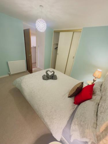 a bedroom with a large bed with a pair of shoes on it at Modern & Cosy 3 Bedroom Inverkeithing home- Ideal for Edinburgh Dunfermline & St Andrews with Free Parking in Inverkeithing