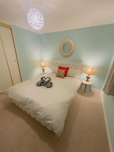 a bedroom with a large white bed with two lamps at Modern & Cosy 3 Bedroom Inverkeithing home- Ideal for Edinburgh Dunfermline & St Andrews with Free Parking in Inverkeithing