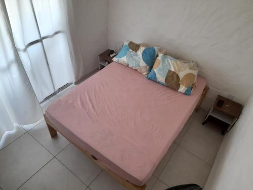 ein kleines rosa Bett in einem Zimmer mit Fenster in der Unterkunft Encanto de Tatuamunha in Pôrto de Pedras