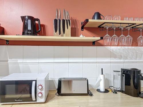 une cuisine avec un grille-pain et un micro-ondes sur un comptoir dans l'établissement Modern and spacious, apartment near Paris, à Aubervilliers