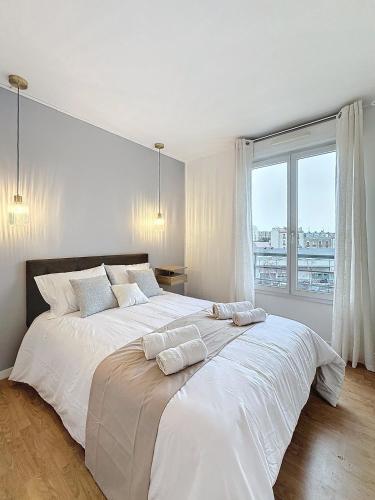 - une chambre blanche avec un grand lit et 2 oreillers dans l'établissement Modern and spacious, apartment near Paris, à Aubervilliers