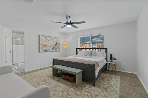 ein Schlafzimmer mit einem Bett und einem Deckenventilator in der Unterkunft Creekview Cottage- Events, Hot Tub, Gameroom in Round Rock
