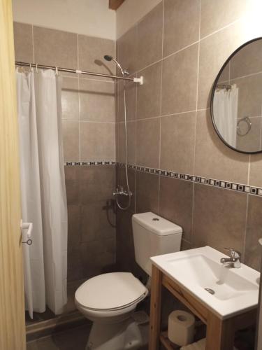 a bathroom with a toilet and a sink and a mirror at Casa Silvia in Bahía Blanca