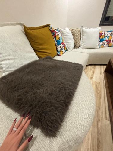 タンジェにあるAppartement de LUXEの女性が黒い毛皮の敷物が敷かれたソファに横たわっている