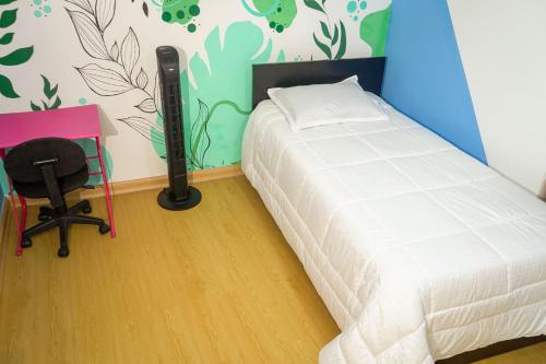 a bedroom with a bed and a desk and a chair at Corazón Verde in Itagüí