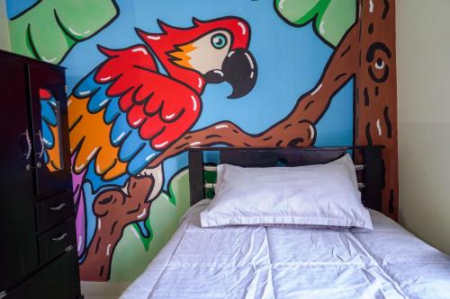 a bedroom with a painting of a chicken on the wall at Corazón Verde in Itagüí