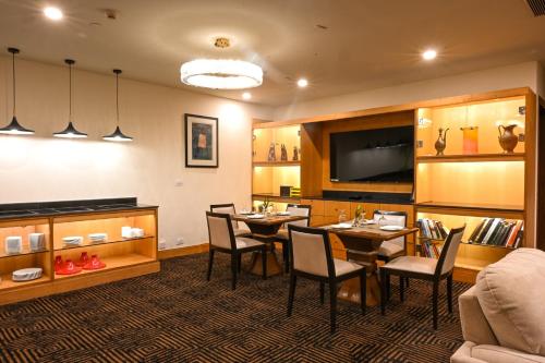 a dining room with tables and chairs and a couch at Crowne Plaza Today Gurugram by IHG in Gurgaon