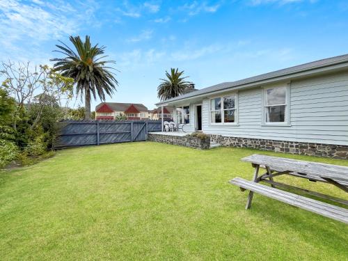 a yard with a bench in front of a house at The Publican's Palace in Whitianga