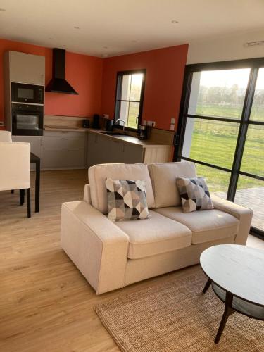 un salon avec un canapé et une table dans l'établissement Les Petites Maisons dans la Prairie - 2, à Maresville