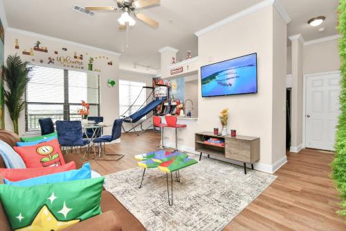 a living room with a couch and a tv on a wall at Nintendo Super Mario Arcade - 2BR-NRG-Med-Center-Galleria in Houston