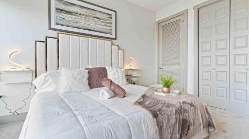 a white bedroom with a large bed with a plant on it at NEW! ChateauOasis PenthouseViews KingBed FreePark in Atlanta