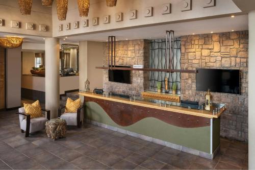 a hotel lobby with a bar and a flat screen tv at Protea Hotel by Marriott Bloemfontein Willow Lake in Bloemfontein