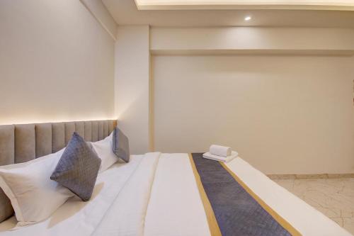 a bedroom with a large white bed with two pillows at Hotel Tree Suites Next Airport Inn in Bengaluru