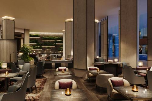 a restaurant with couches and tables and chairs at JW Marriott Auckland in Auckland
