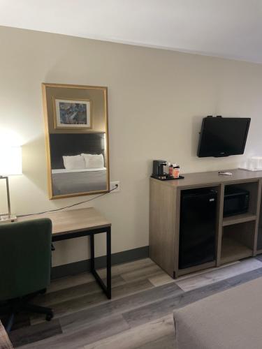 a room with a television and a desk with a table sidx sidx sidx at Quality Inn & Suites Goodyear - Phoenix West in Goodyear