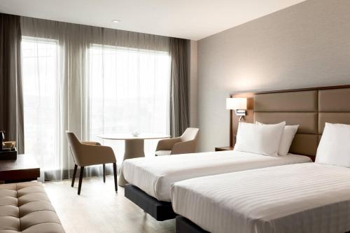 a hotel room with two beds and a table at AC Hotel by Marriott Belfast in Belfast