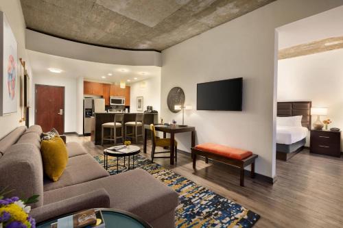 a living room with a couch and a bedroom at Twelve Downtown, Autograph Collection in Atlanta