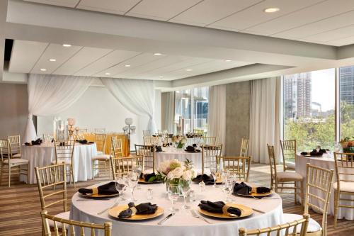 a banquet room with tables and chairs and a large window at Twelve Downtown, Autograph Collection in Atlanta