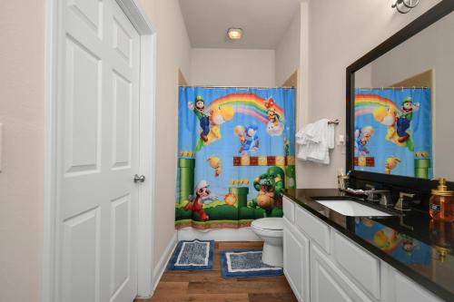 a bathroom with a dinosaur shower curtain and a toilet at The Super Mario Bros Movie - 2BR-NRG-Med Center-Galleria in Houston