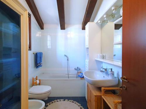 a bathroom with a tub and a sink and a toilet at House in Luino with Green Garden and City Views in Luino