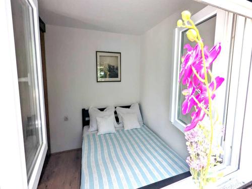 Zimmer mit einem Bett mit weißen Kissen und einem Fenster in der Unterkunft Holiday Home Jaga - Three bedroom Holiday Home with swimming pool in Biograd na Moru