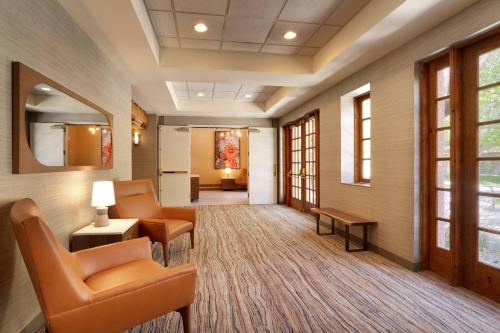 a waiting room with chairs and tables and windows at Courtyard by Marriott Albuquerque in Albuquerque