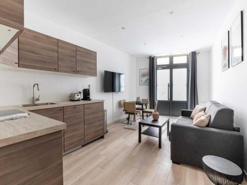 un salon avec un canapé et une cuisine dans l'établissement Modern apartment -1BR-4P- Saint-Germain-des-Prés, à Paris