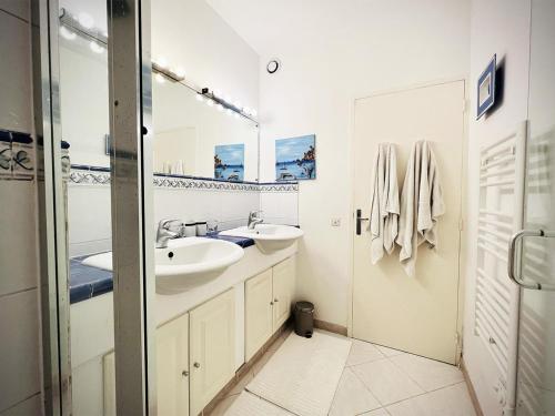 une salle de bain blanche avec deux lavabos et une douche dans l'établissement La Bussola, à Théoule-sur-Mer