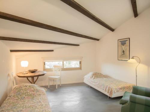 une chambre avec deux lits, une table et une chaise dans l'établissement Maison l Arc, à Valbonne