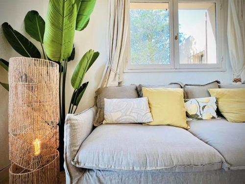 - un canapé avec des oreillers dans une chambre avec une fenêtre dans l'établissement La Bussola, à Théoule-sur-Mer