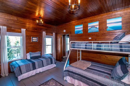 1 Schlafzimmer mit 2 Betten in einer Holzhütte in der Unterkunft Whispering Waters Farmhouse and Wedding Barn in Paris