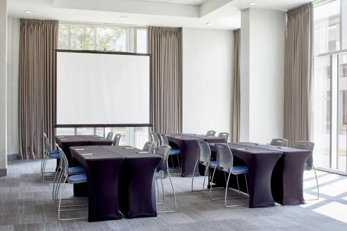 a conference room with tables and chairs and a large window at Aloft Austin at The Domain in Austin