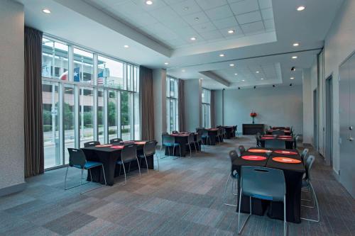 a dining room with tables and chairs and windows at Aloft Austin at The Domain in Austin