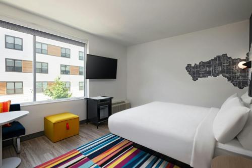 a bedroom with a bed and a desk and a window at Aloft Austin Southwest in Austin